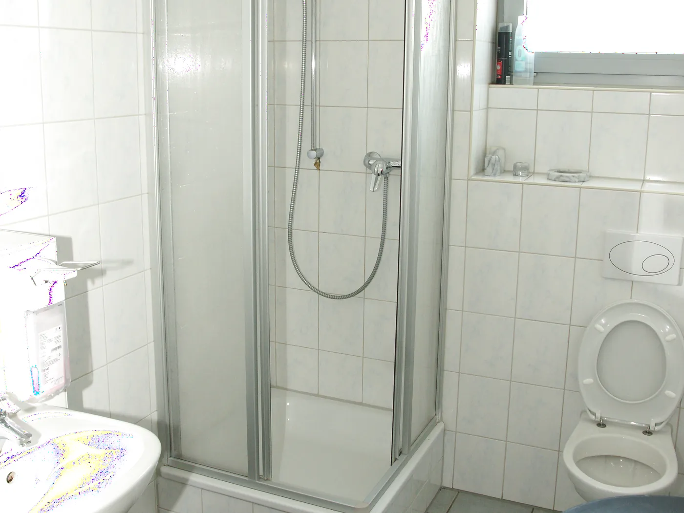 Geflieste Duschkabine mit Waschbecken und WC im Fahrerbereich der Waschanlage