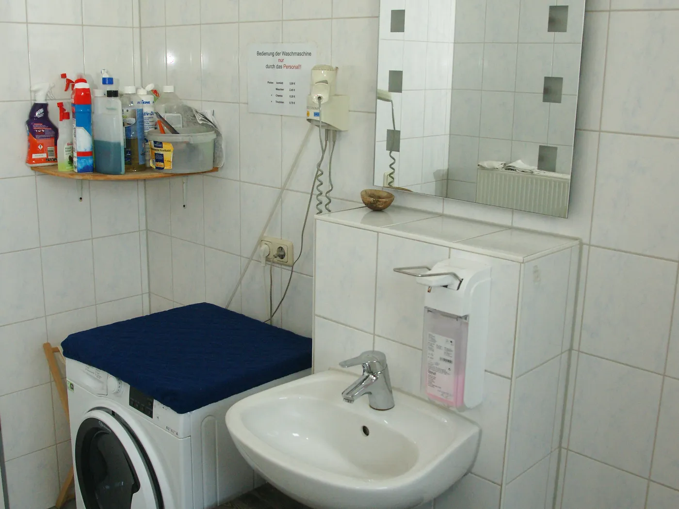 Waschraum mit Waschmaschine, Waschbecken, Spiegel und Fön