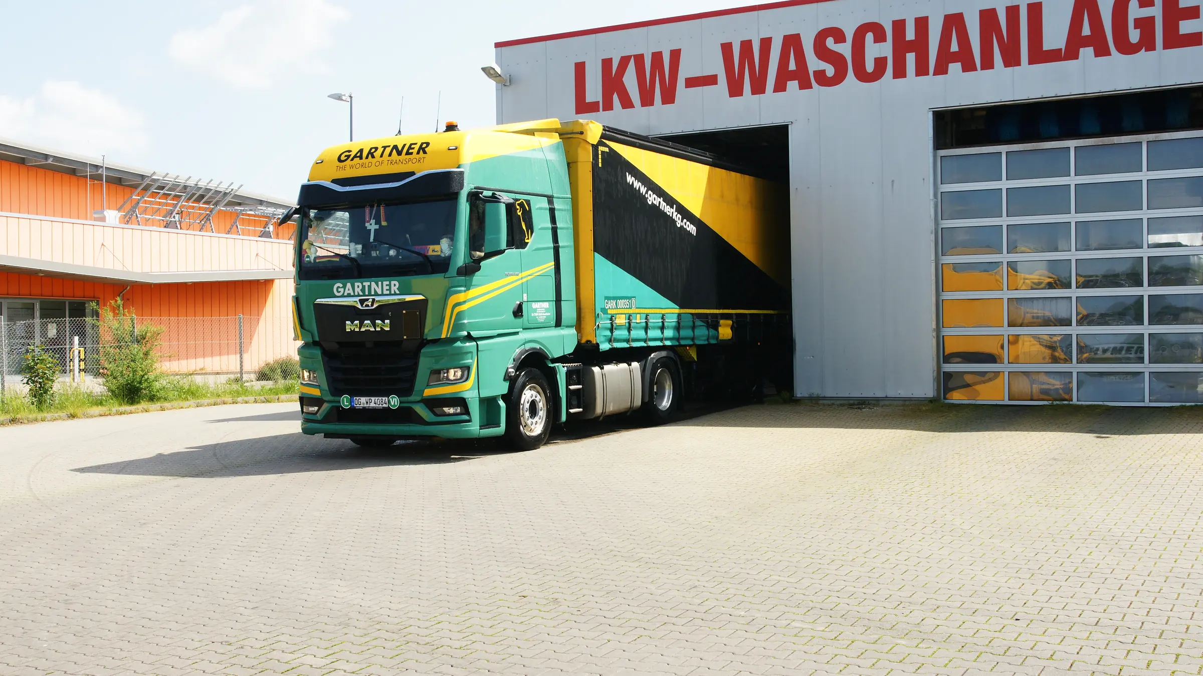 Sattelzug verlässt die Waschhalle des Service-Park im GVZ Erfurt, an der Fassade der Schriftzug LKW-Waschanlage